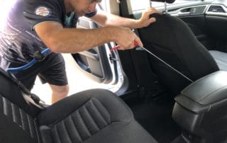 cleaning in between car seats with an air gun to get into every nook and cranny